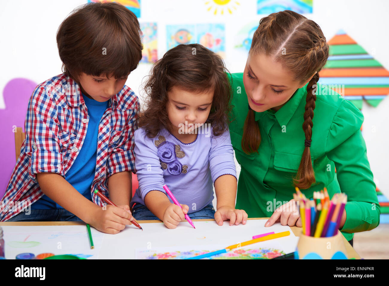 Teacher with children drawing Stock Photo - Alamy