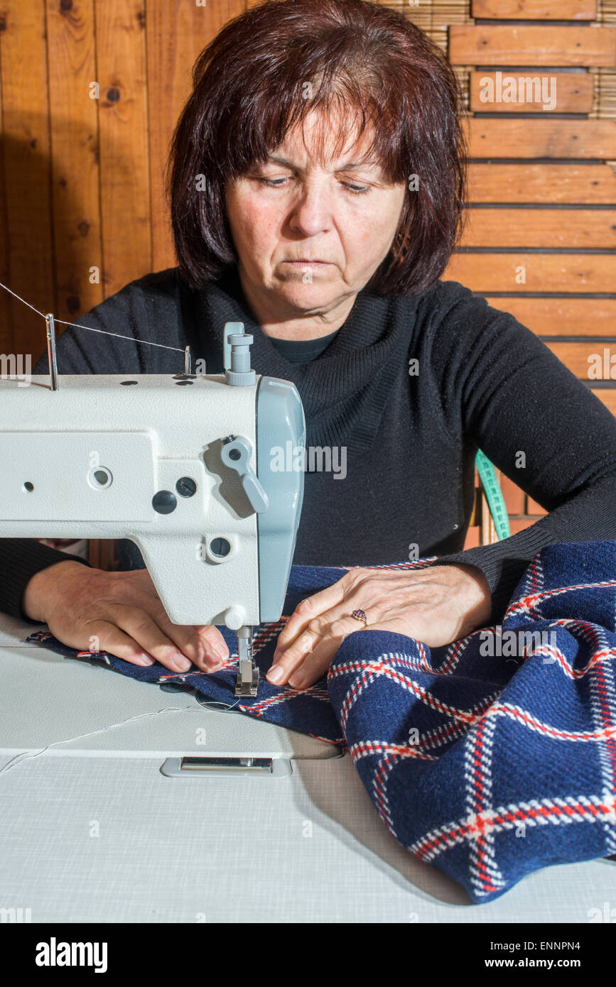 Woman sewing on white sewing machine Stock Photo Alamy