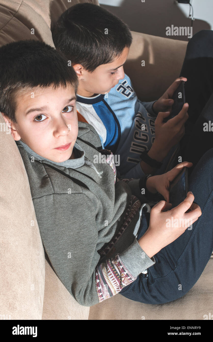 Children playing with their smartphones. Two boys with mobile phones Stock Photo