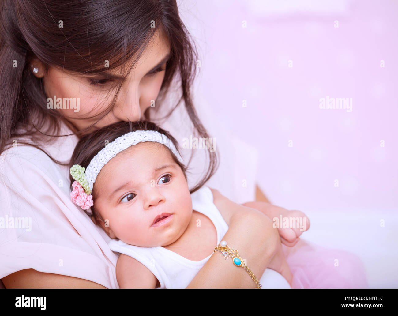Closeup portrait of beautiful woman with gentleness kissing her cute newborn daughter, enjoying parenthood, mother's love Stock Photo