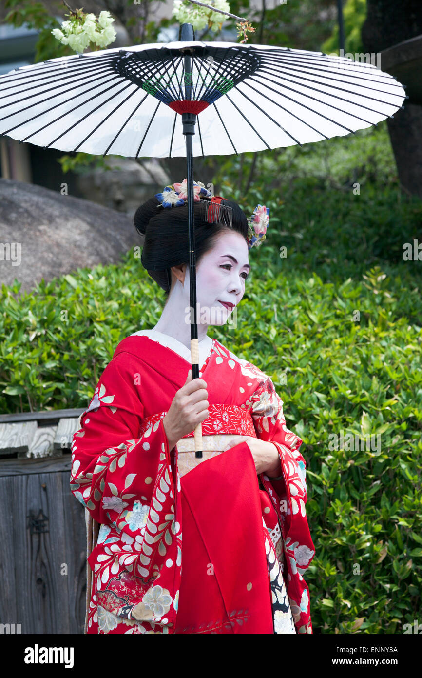 Geisha in traditional clothing and oil-paper umbrella (wagasa) in Kyoto, Japan Stock Photo