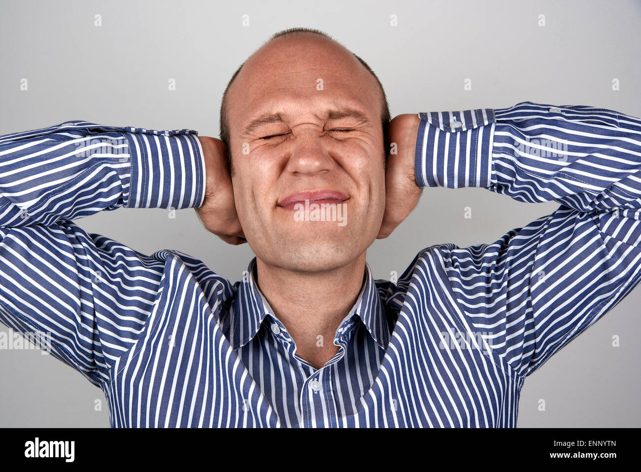 Man with eyes and ears tightly closed with hands Stock Photo Alamy
