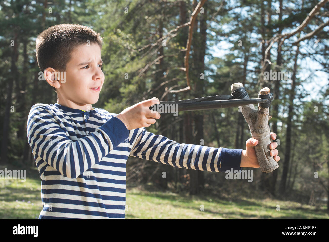 Child play with sling toy in the forest. Stock Photo