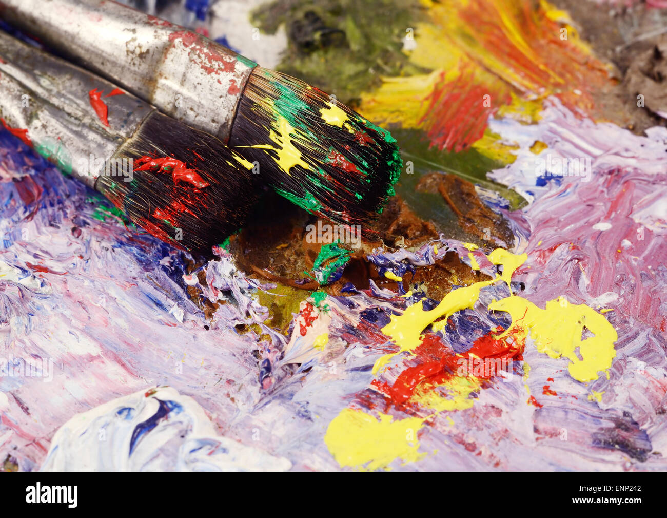 Art still life - two paintbrushes and dirty palette with colourful  paints,background for creative art design Stock Photo