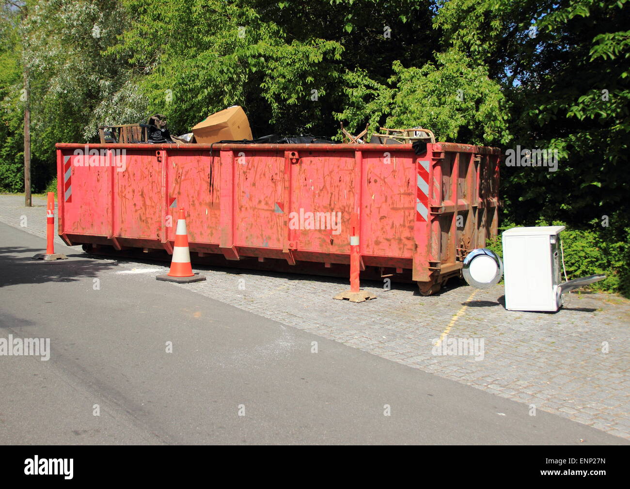 Container with trash at parkinglot plants in background Stock Photo - Alamy