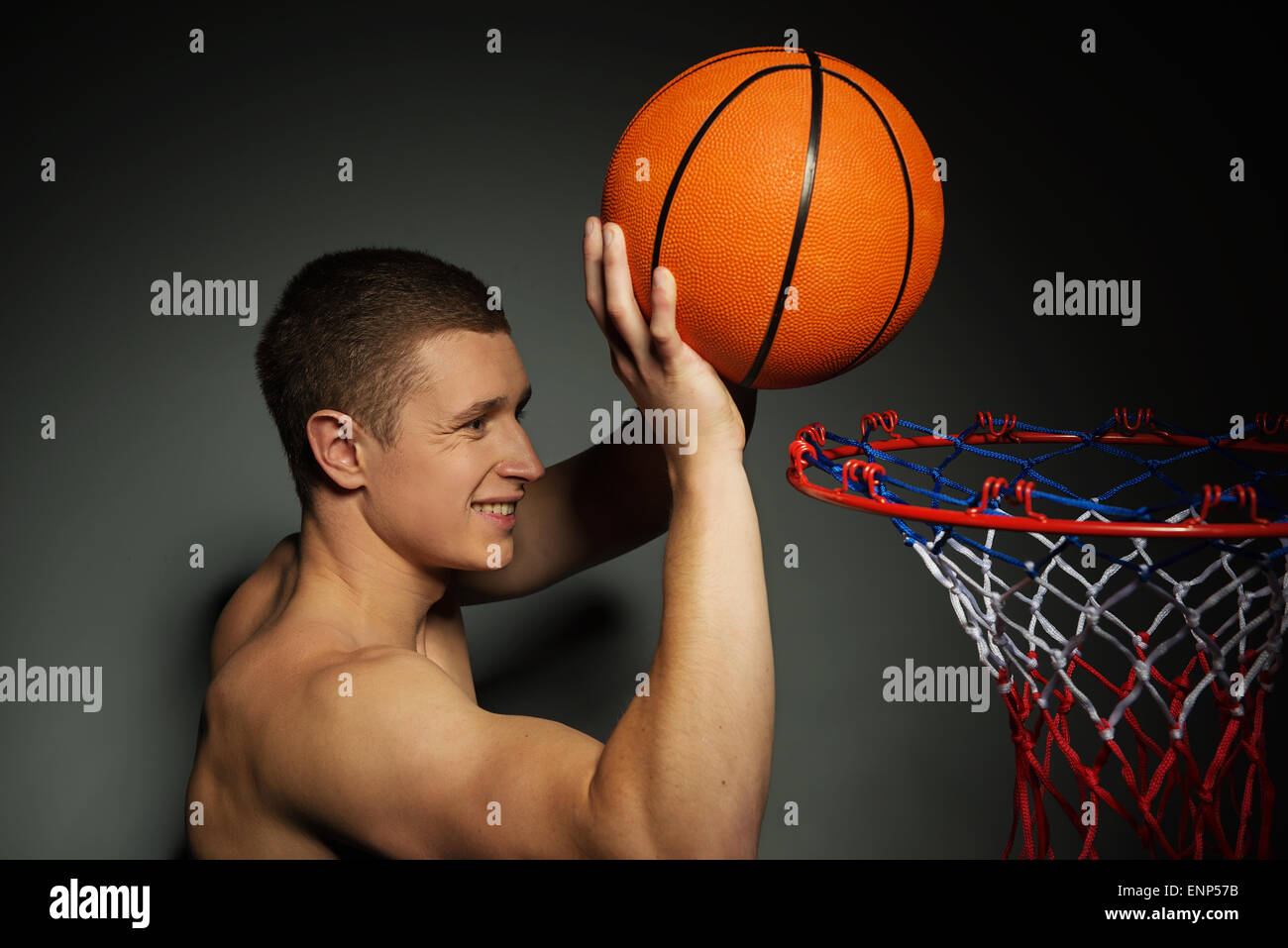 Basketball athlete throwing ball into the basket Stock Photo