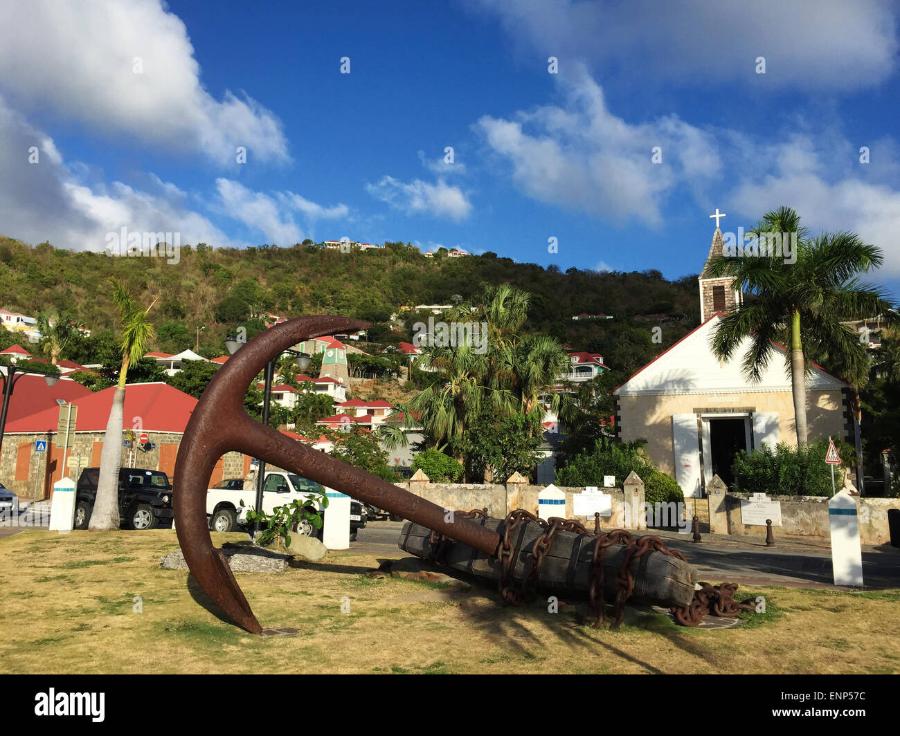 Saint-Barthélemy, French West Indies, Caribbean: a sculpture in the form of an anchor, the skyline of Gustavia and the Anglican Church Stock Photo