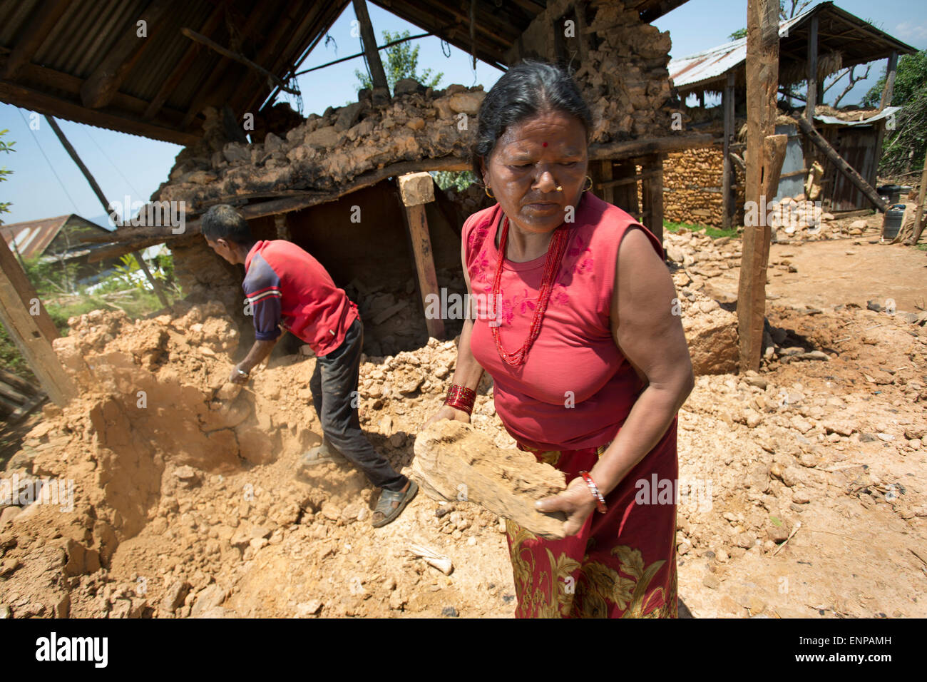 A wife and husband clear out their destroyed home following the destructive 2015 earthquake in Nepal. Stock Photo