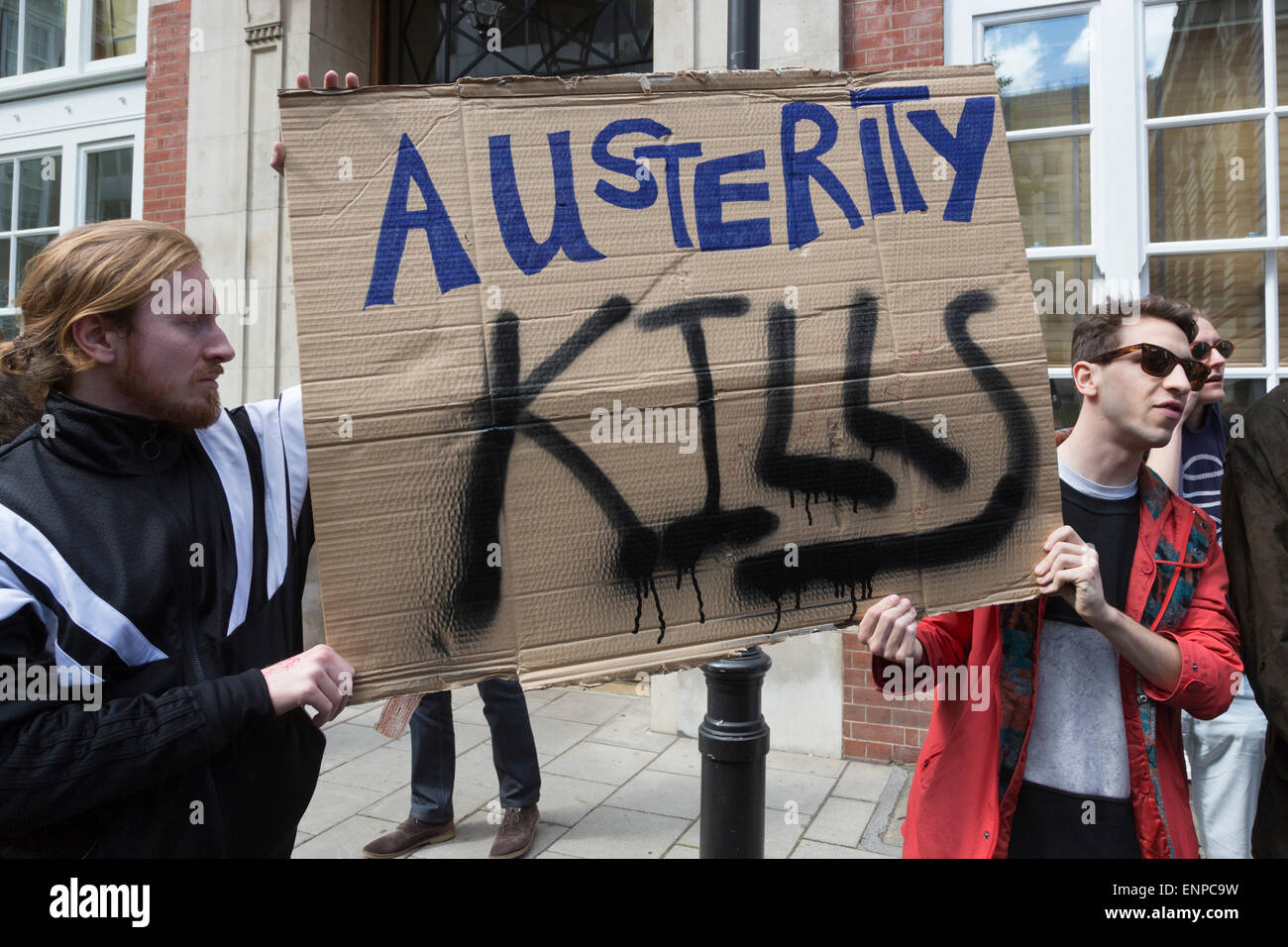 London, UK. 9 May 2015. Pictured: Protesters outside the Tory General Election campaign offices in Matthew Parker Street with an Austerity Kills placard. Several hundred protesters gathered in Westminster and marched through Central London two days after the 2015 General Election in protest of the new David Cameron/Conservative Party Government and more cuts to welfare. Photo: Nick Savage/Alamy Live News Stock Photo