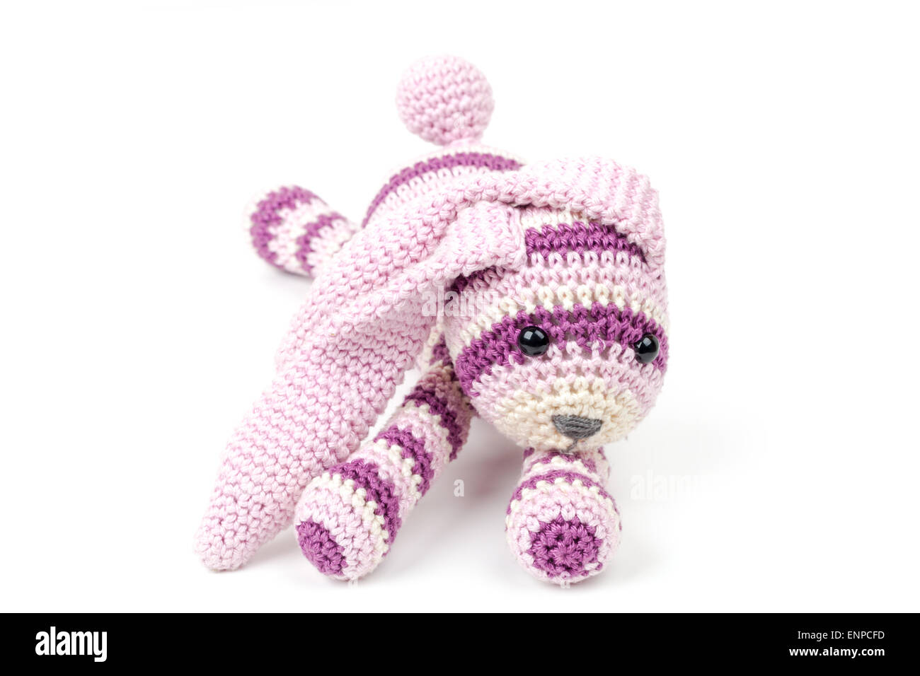 Knitted pink rabbit toy lays isolated on white background, selective ...
