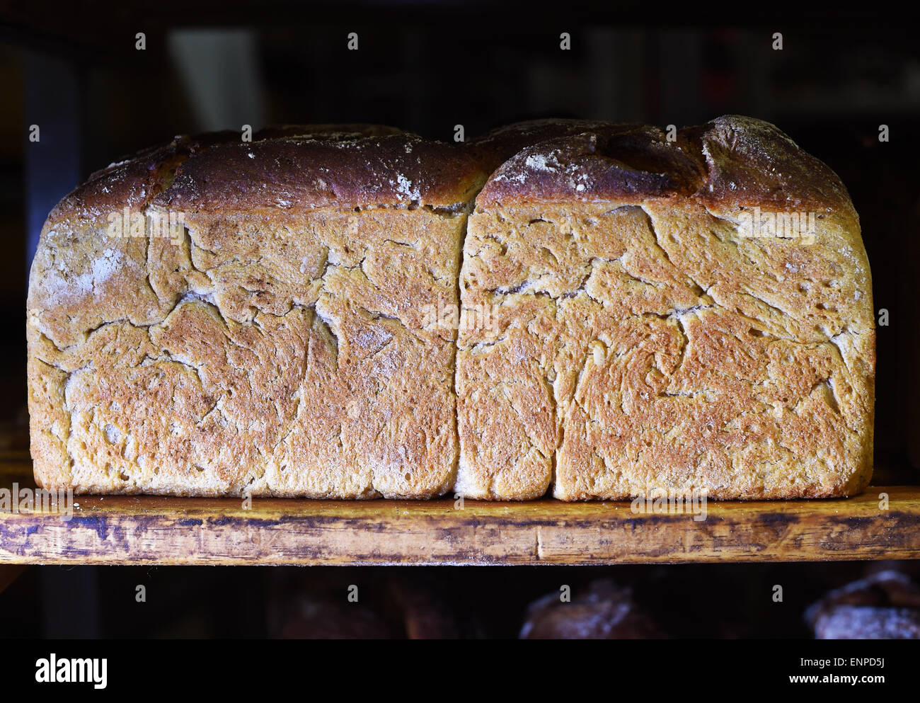 Berlin, Germany. 07th May, 2015. A loaf of whole-grain bread has been placed on wooden boards at Beumer & Lutum Baeckerei GmbH (Beumer & Lutum Bakery) in Berlin, Germany, 07 May 2015. 3000 to 5000 loaves of bread are produced every day without using bread improvers and premixtures and sold in 5 branches or organic food stores. The company has also joined the 'Week of open bakeries', an event initiated by organic bakeries in Berlin. Photo: Jens Kalaene/dpa/Alamy Live News Stock Photo