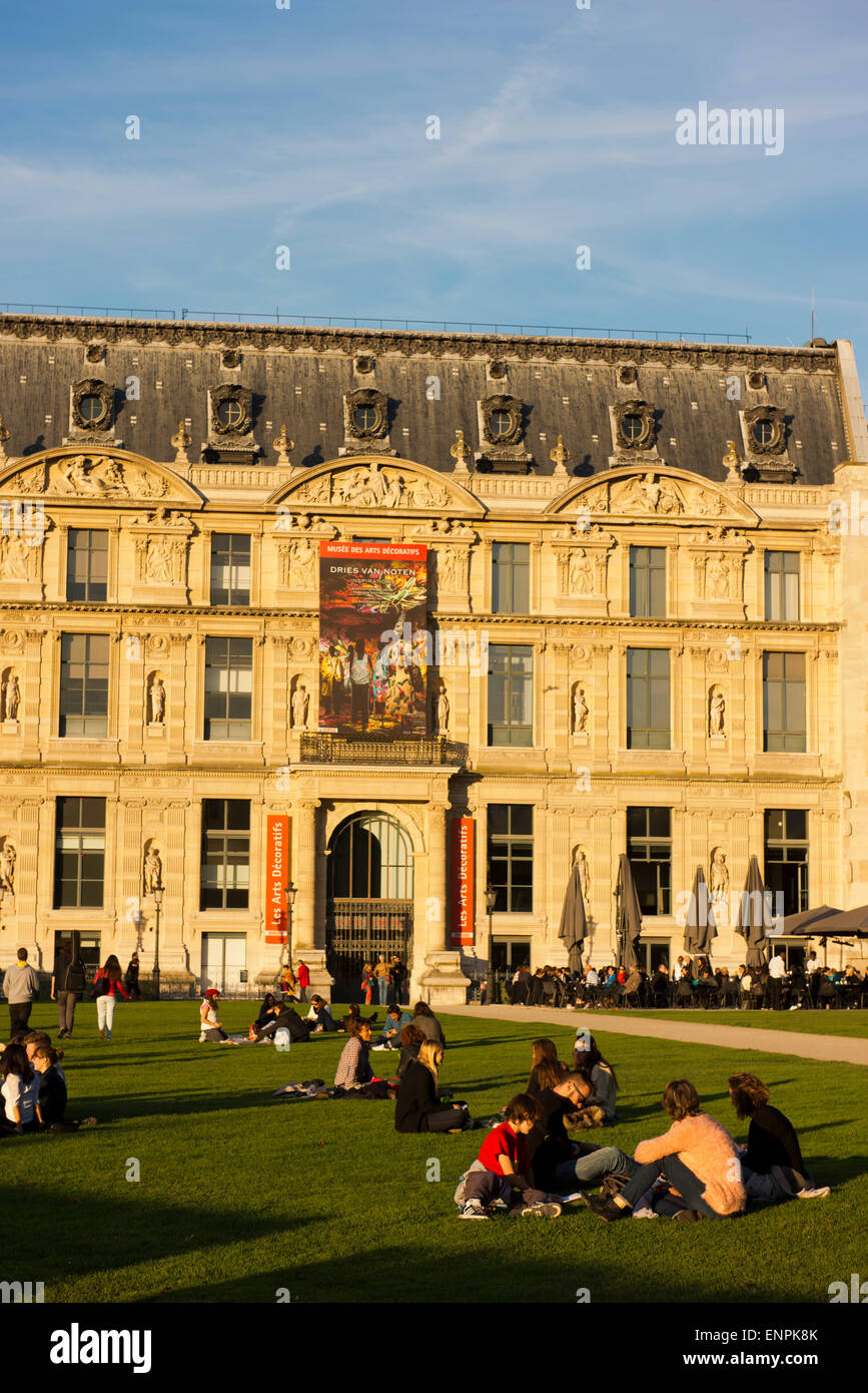 People relax on the grass outside the Louvre Museum. Stock Photo