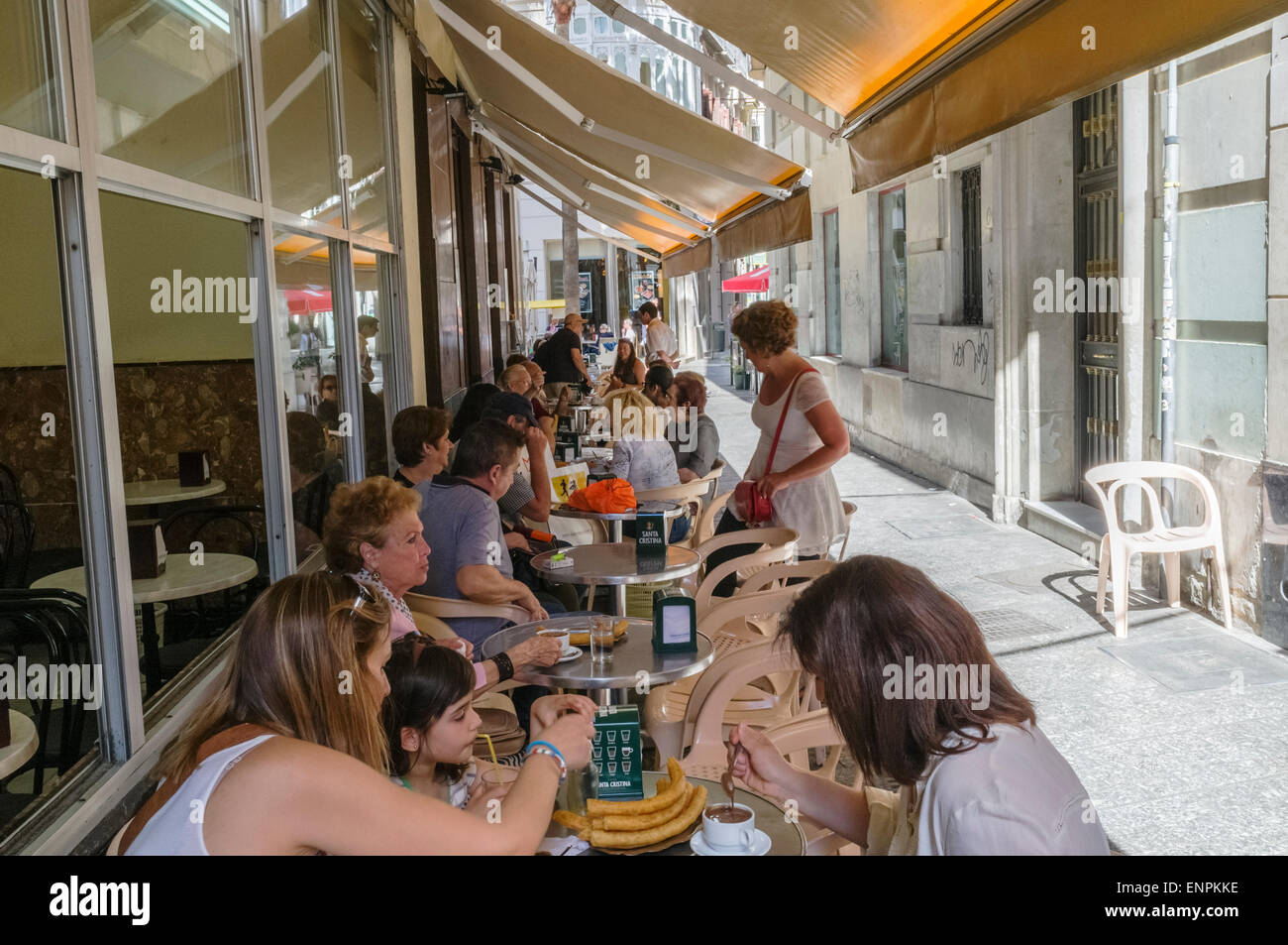 Malaga, Spain. People eating "churros" (typical frieddough pastry) with hot chocolate at a