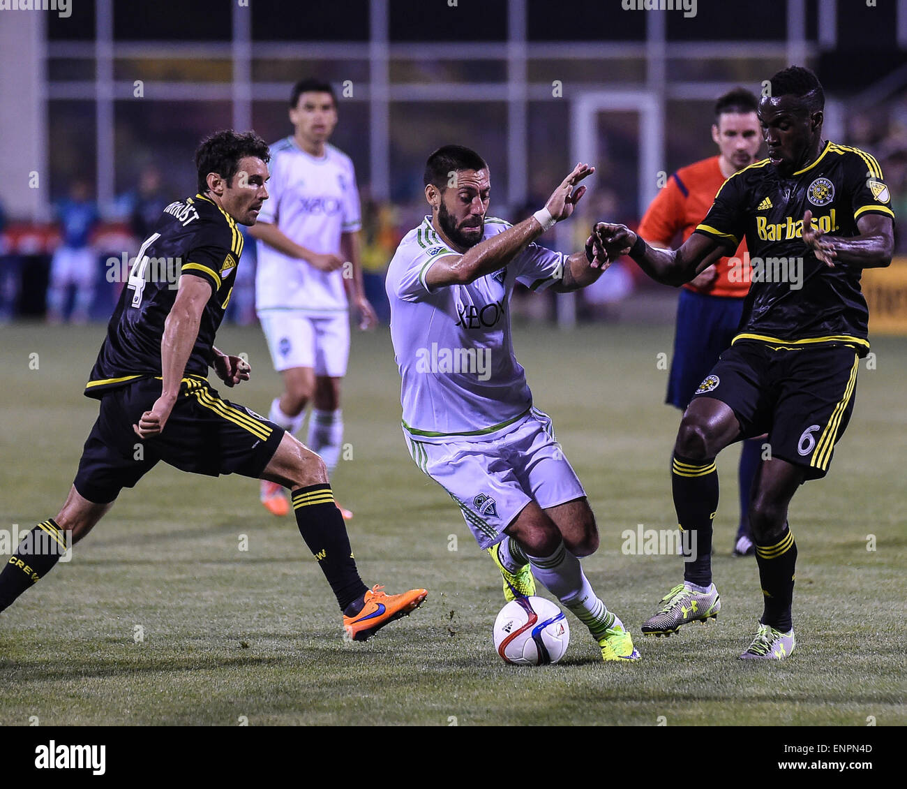 Seattle Sounders FC forward Clint Dempsey (2) dribbles the ball through Columbus Crew defender Michael Parkhurst (4) and Columbus Crew midfielder Tony Tchani (6) during a regular season match between Columbus Crew SC and Seattle Sounders FC at Mapfre Stadium in Columbus, OH. Stock Photo