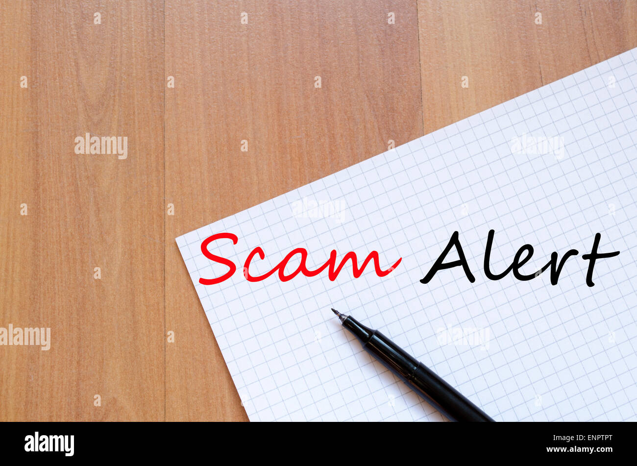 White blank notepad on office wooden table Scam Alert concept Stock Photo