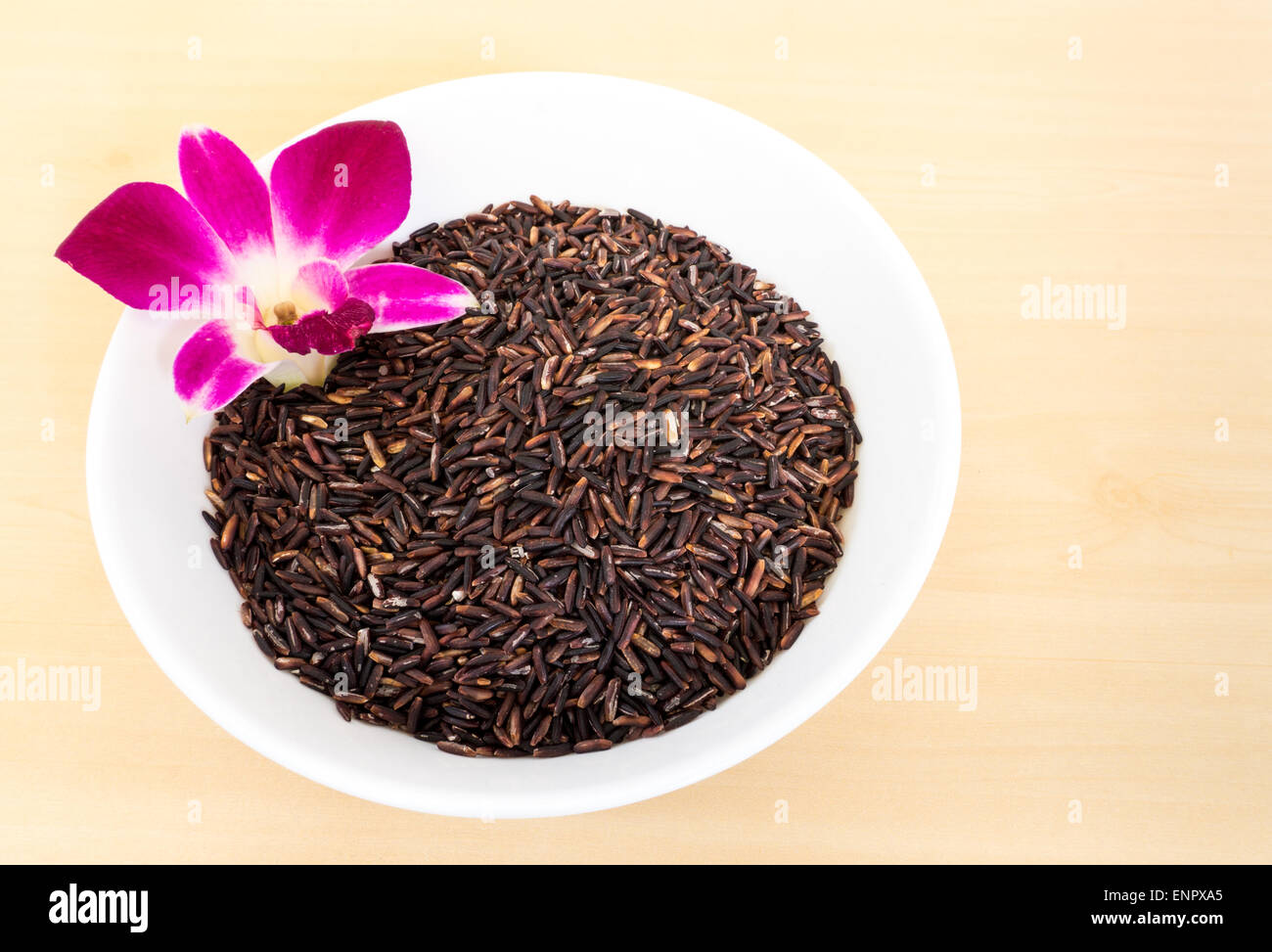Brown Jasmine Rice with Orchid Flower in a White Bowl Stock Photo