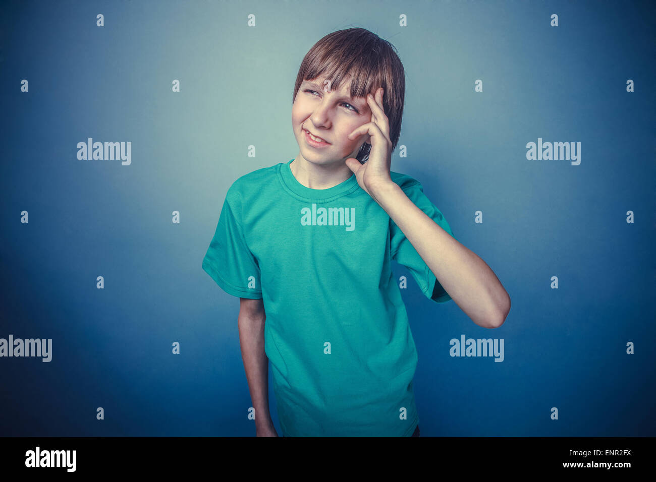 Boy, teenager, twelve years old, green a in tshirt holding temple a, a
