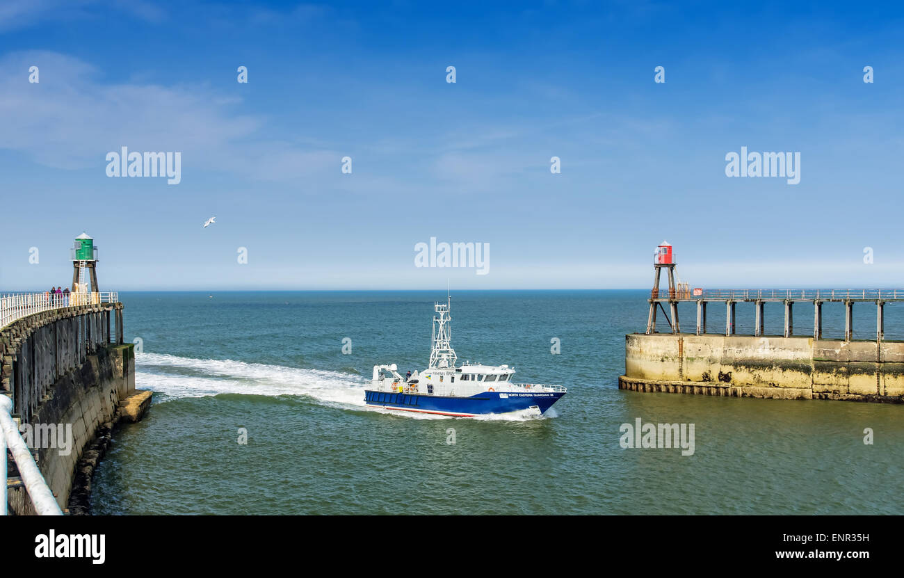 Fast boat entering harbour between two piers Stock Photo Alamy