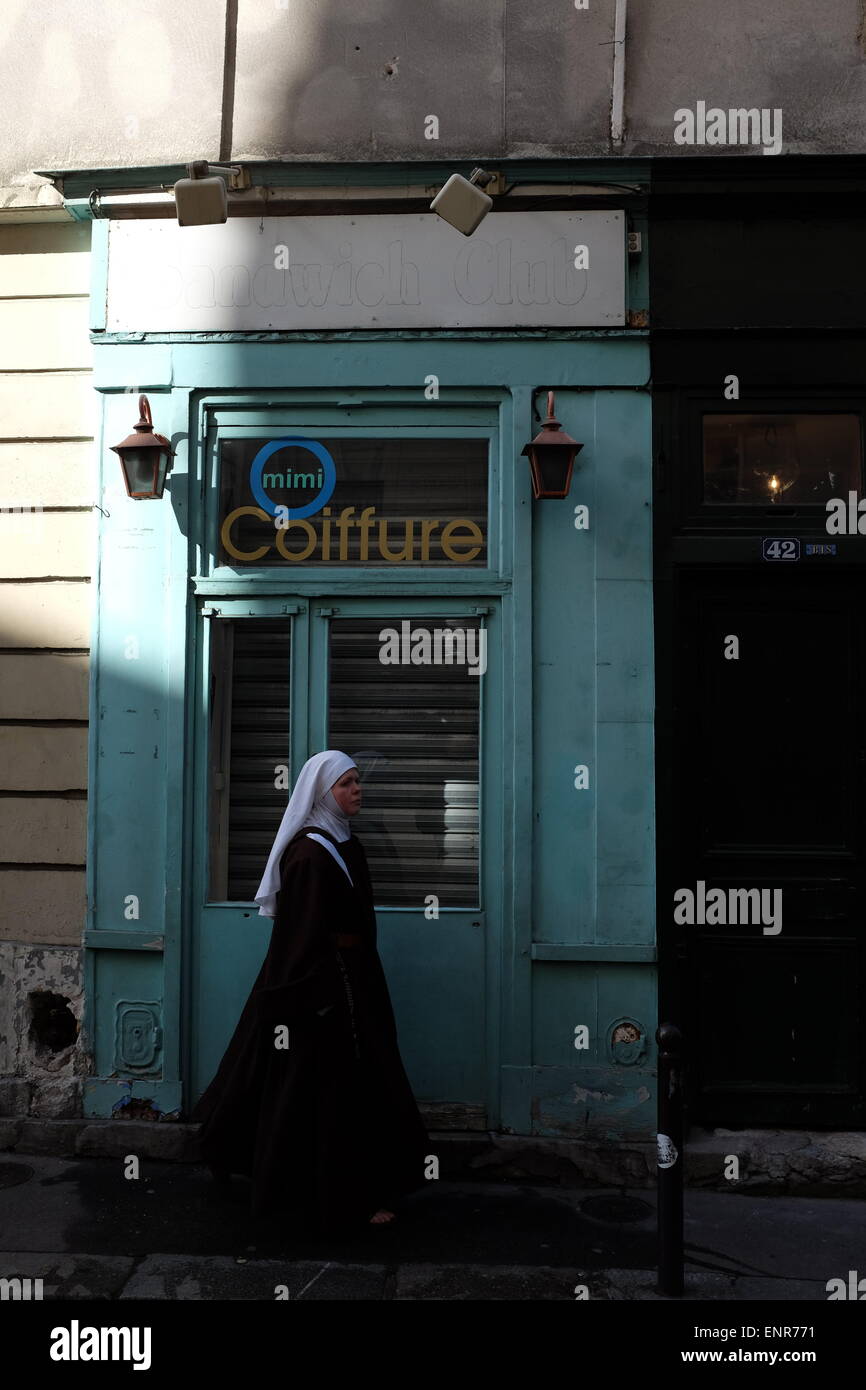 Nun walking past hairdressers in Paris, France Stock Photo Alamy