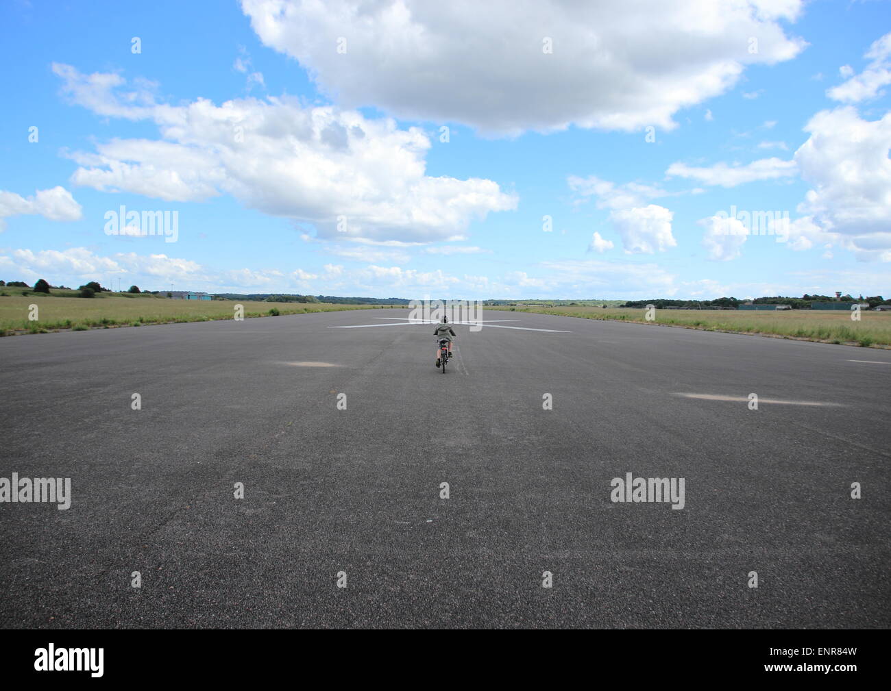 Biking child with helmet on airplane runway Stock Photo