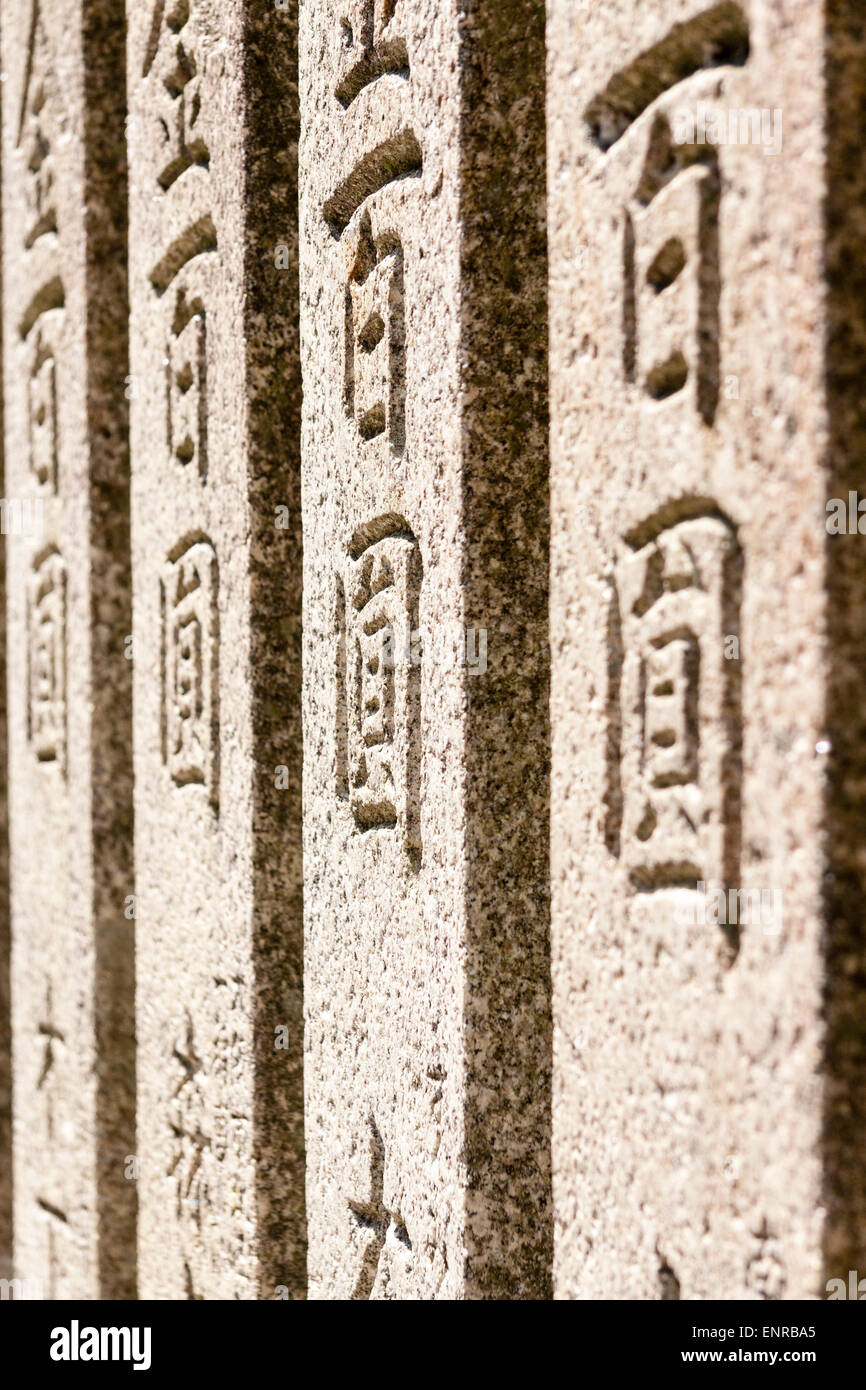 Japan, Takarazuka. Kiyoshikojin Seichoji shrine. View along four stone tablets, with names of benefactors vertically engraved on them. Stock Photo