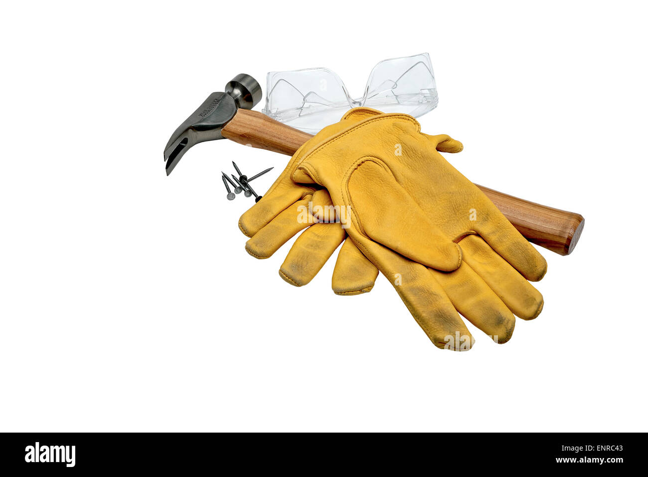 Clear safety goggles with hammer, nails and mustard color used work gloves isolated on white Stock Photo