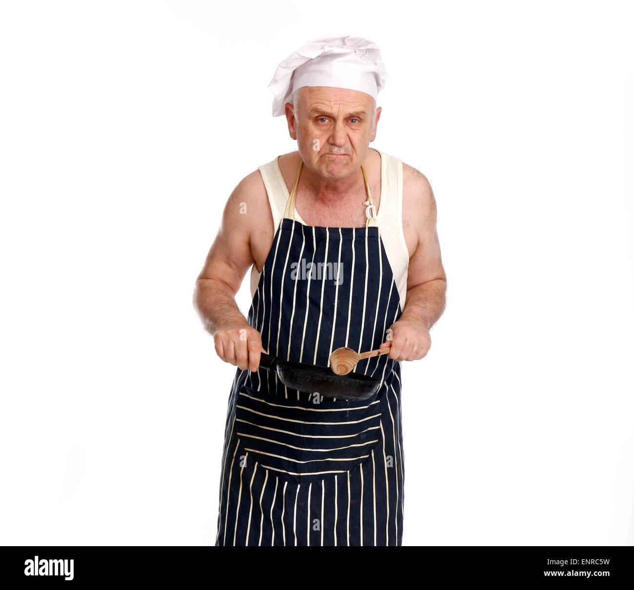 Grumpy foul tempered man as a low grade chef or cook in a greasy spoon cafe, while he cooks. Stock Photo