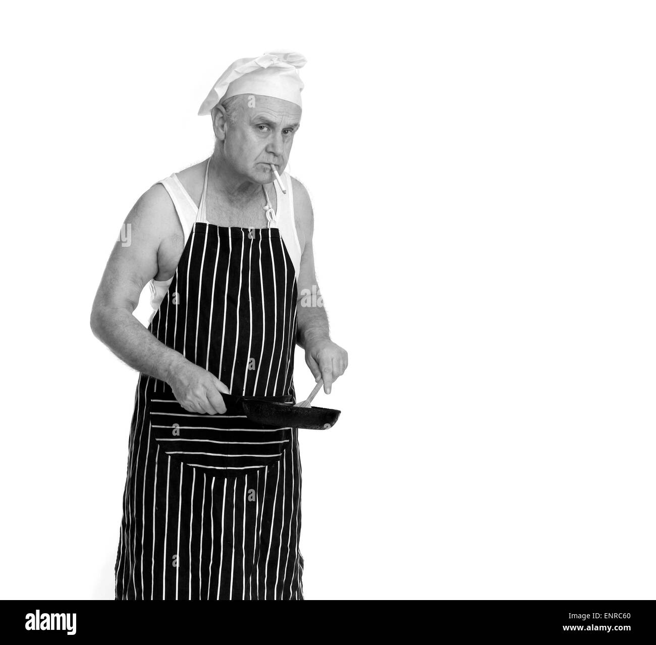 Man as a low grade chef or cook in a greasy spoon Cafe, smoking while he cooks. 24th April 2015 Stock Photo