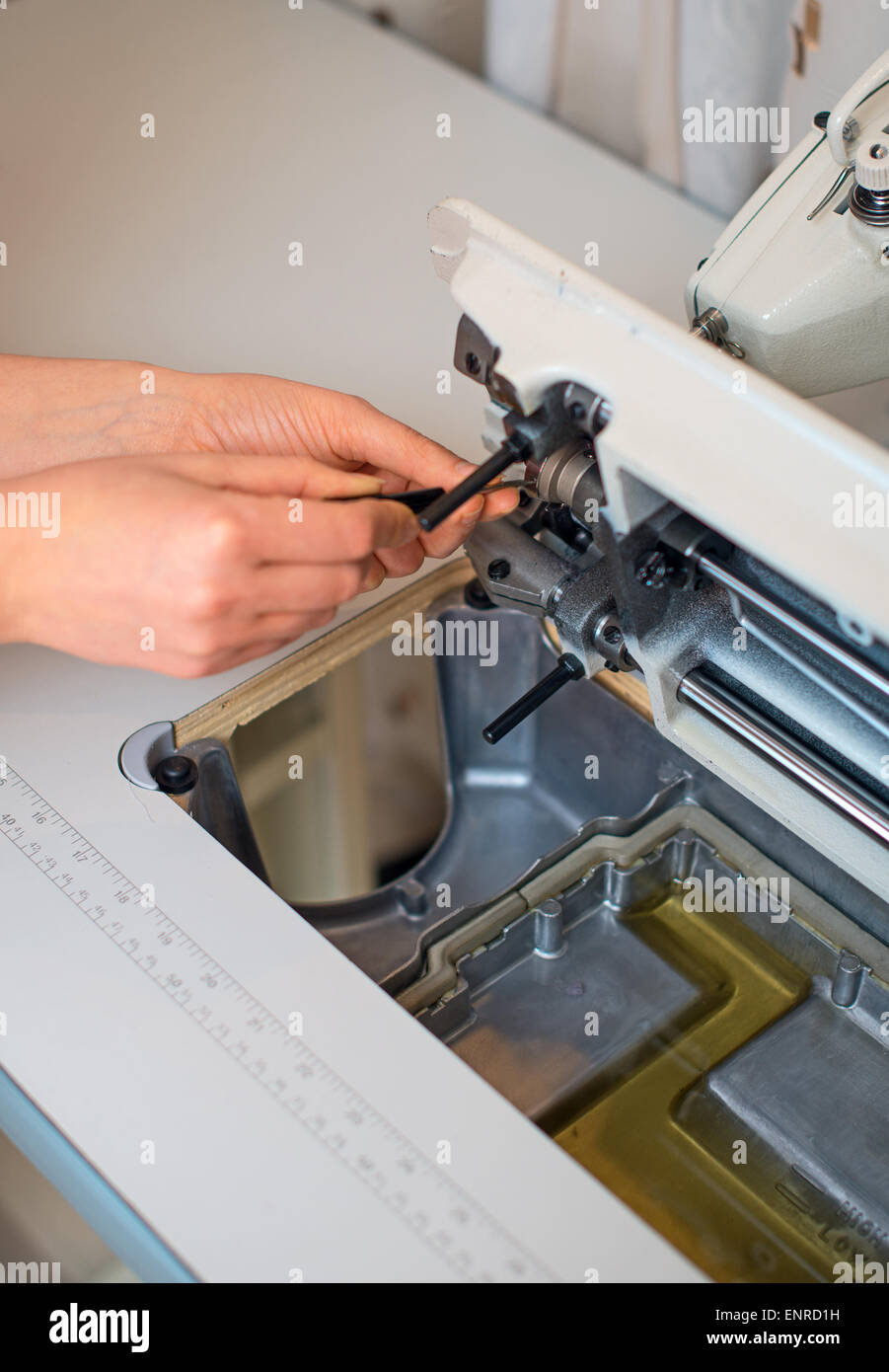 Female hand fixing sewing machine. Maintenance Stock Photo - Alamy