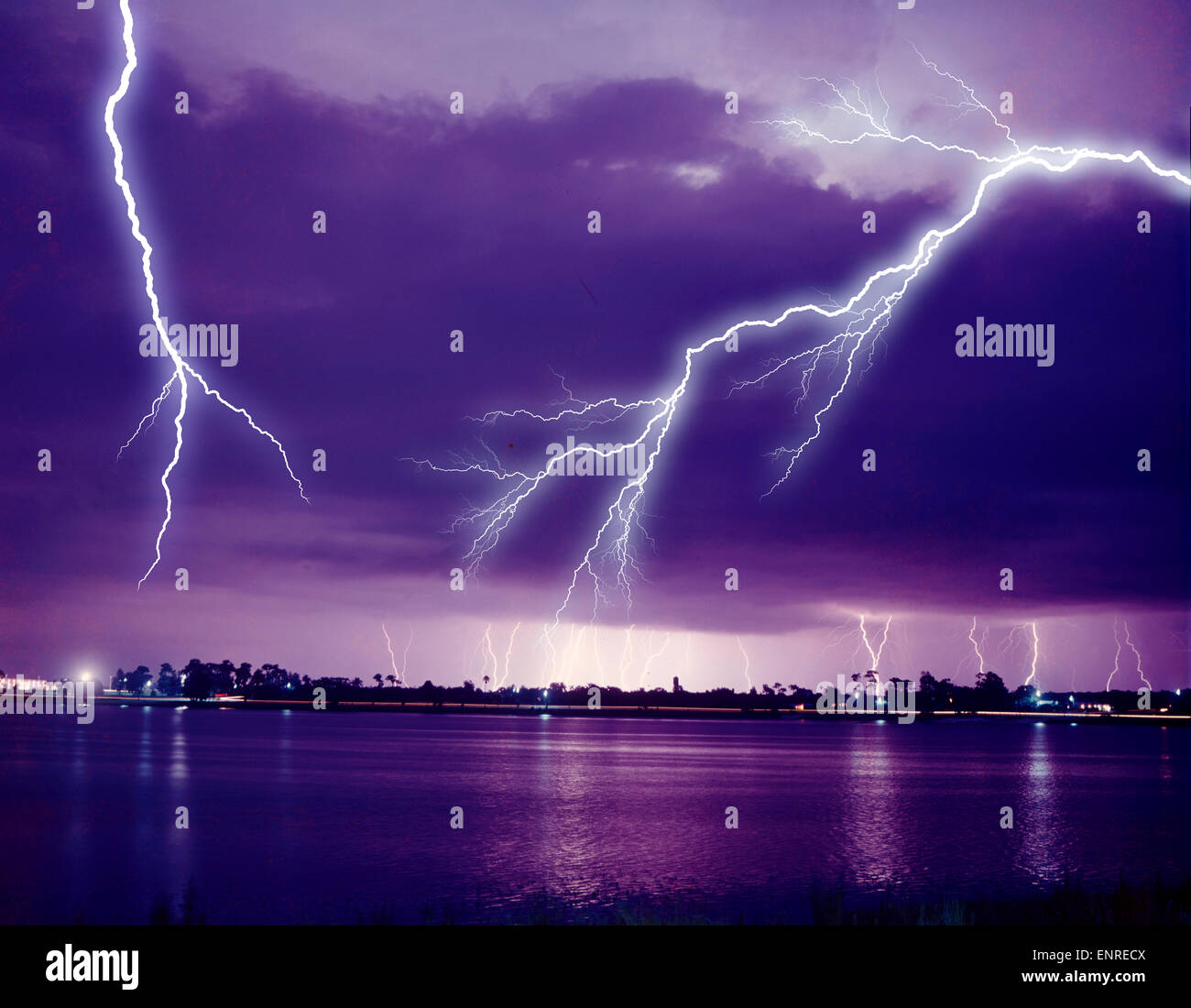 multiple lightning bolts reflected in tropical lake Stock Photo