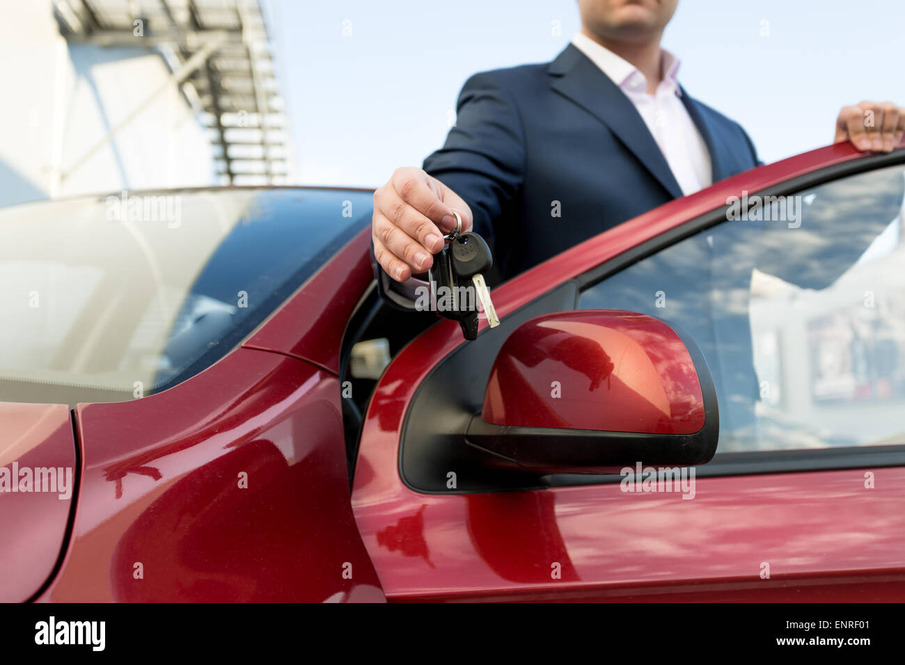 Closeup photo of handsome car salesman giving keys Stock Photo - Alamy