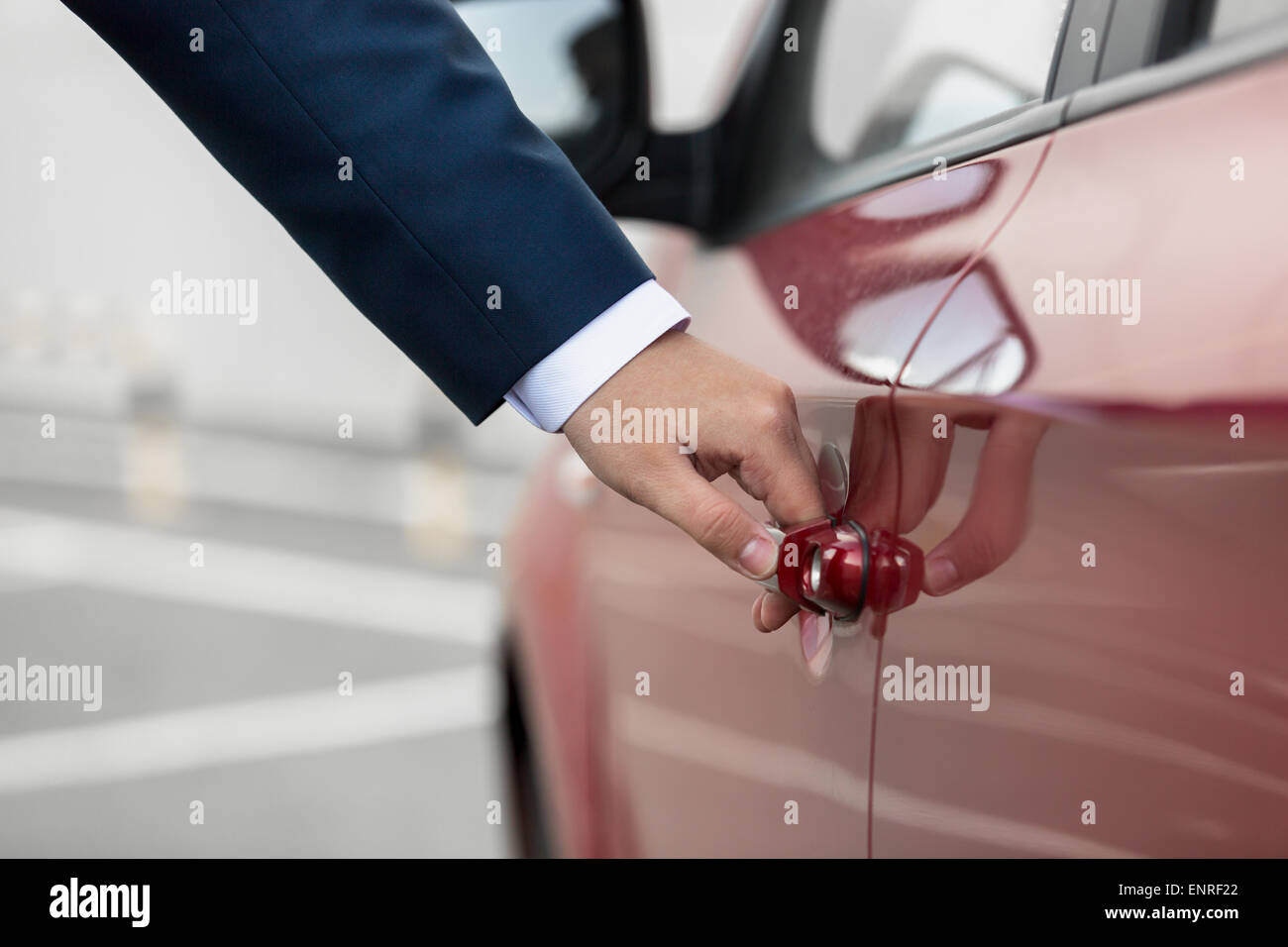 Closeup photo of young businessman pulling car door handle Stock Photo