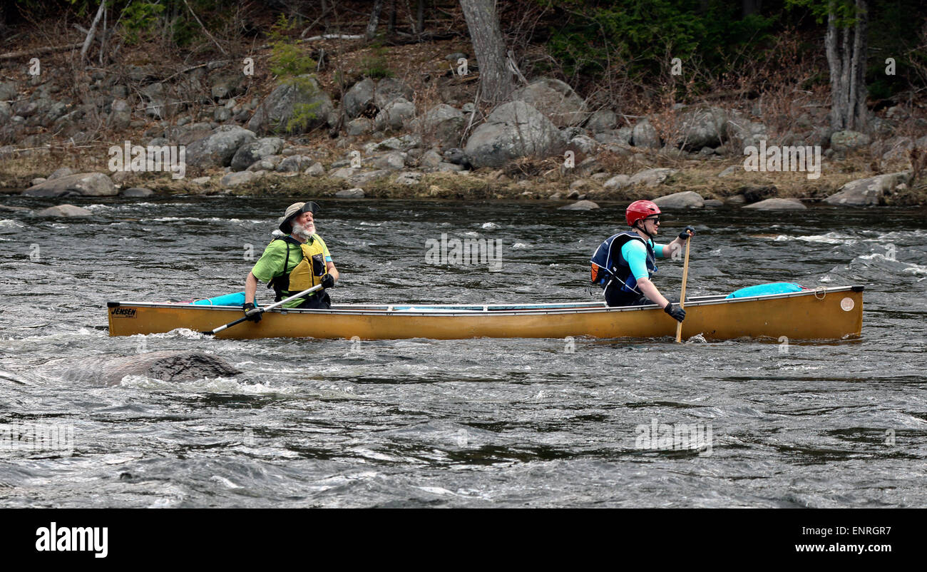 Two men in a canoe shooting running the rapids on the Hudson River New