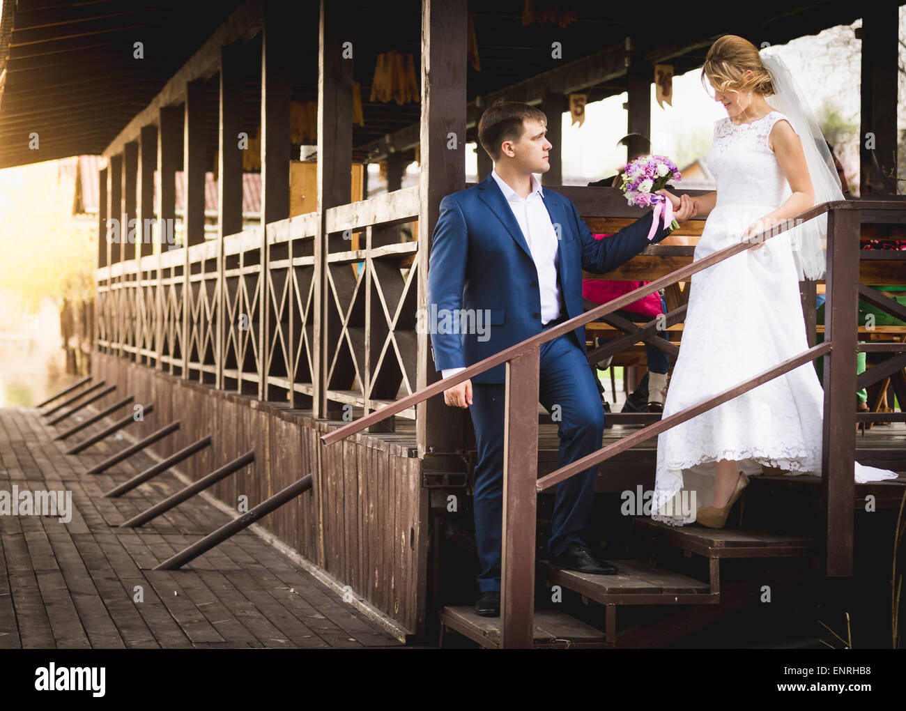 Beautiful just married couple posing on berth at sunset Stock Photo - Alamy