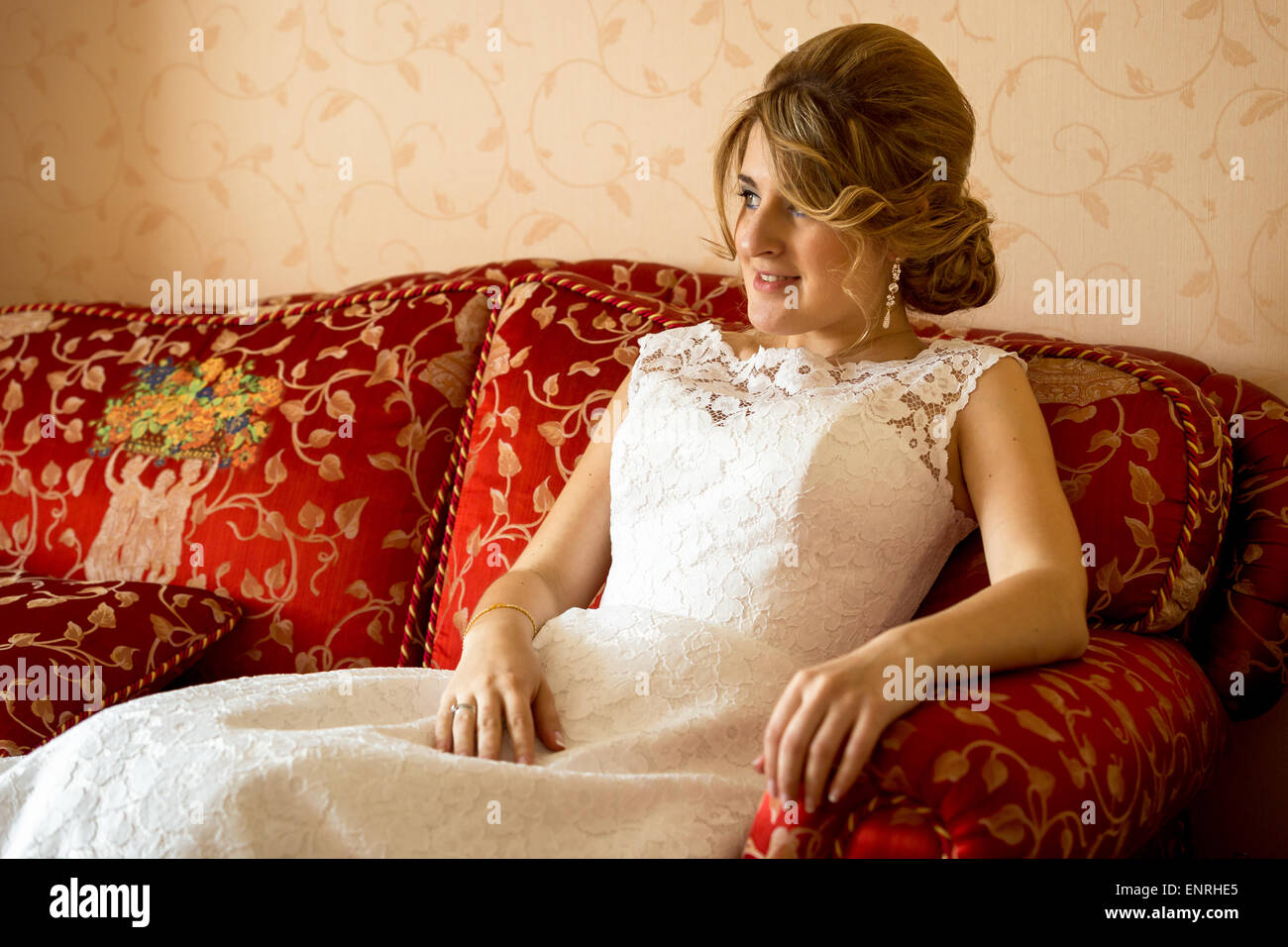 Portrait of beautiful bride relaxing on sofa at luxurious hotel room Stock Photo