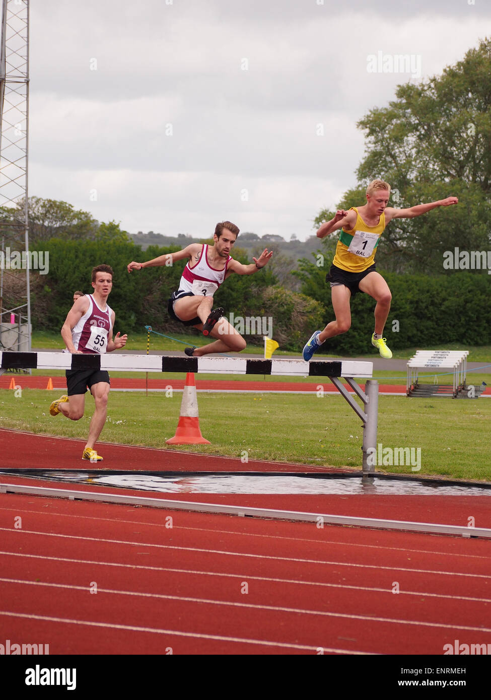 Athletes take on the water jump during a steeplechase race Stock Photo