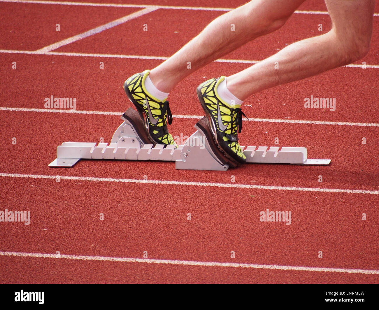 An Athletes feet placed firmly onto starting blocks, ready to start a race Stock Photo