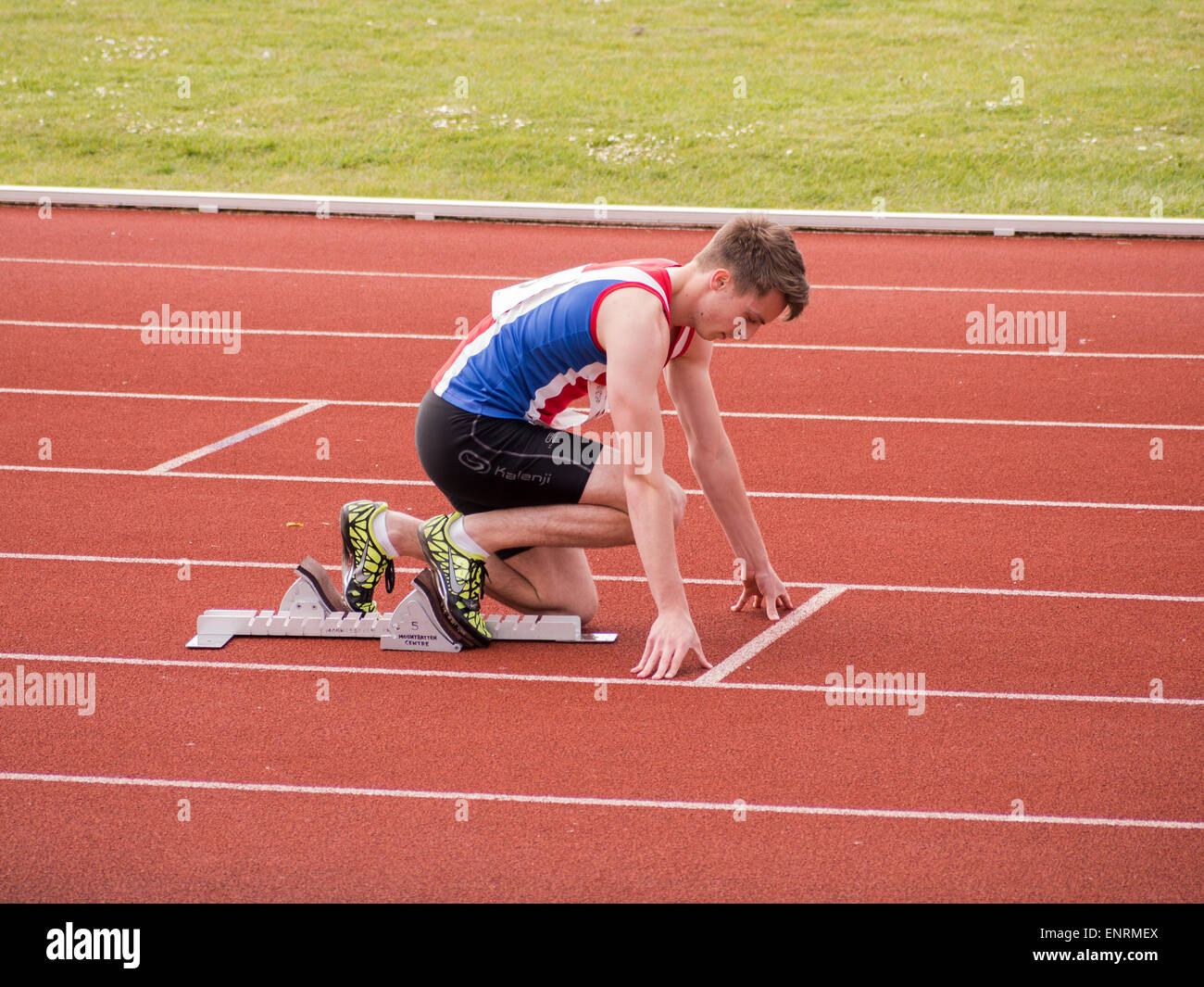 A runner on starting blocks at an athletics track Stock Photo