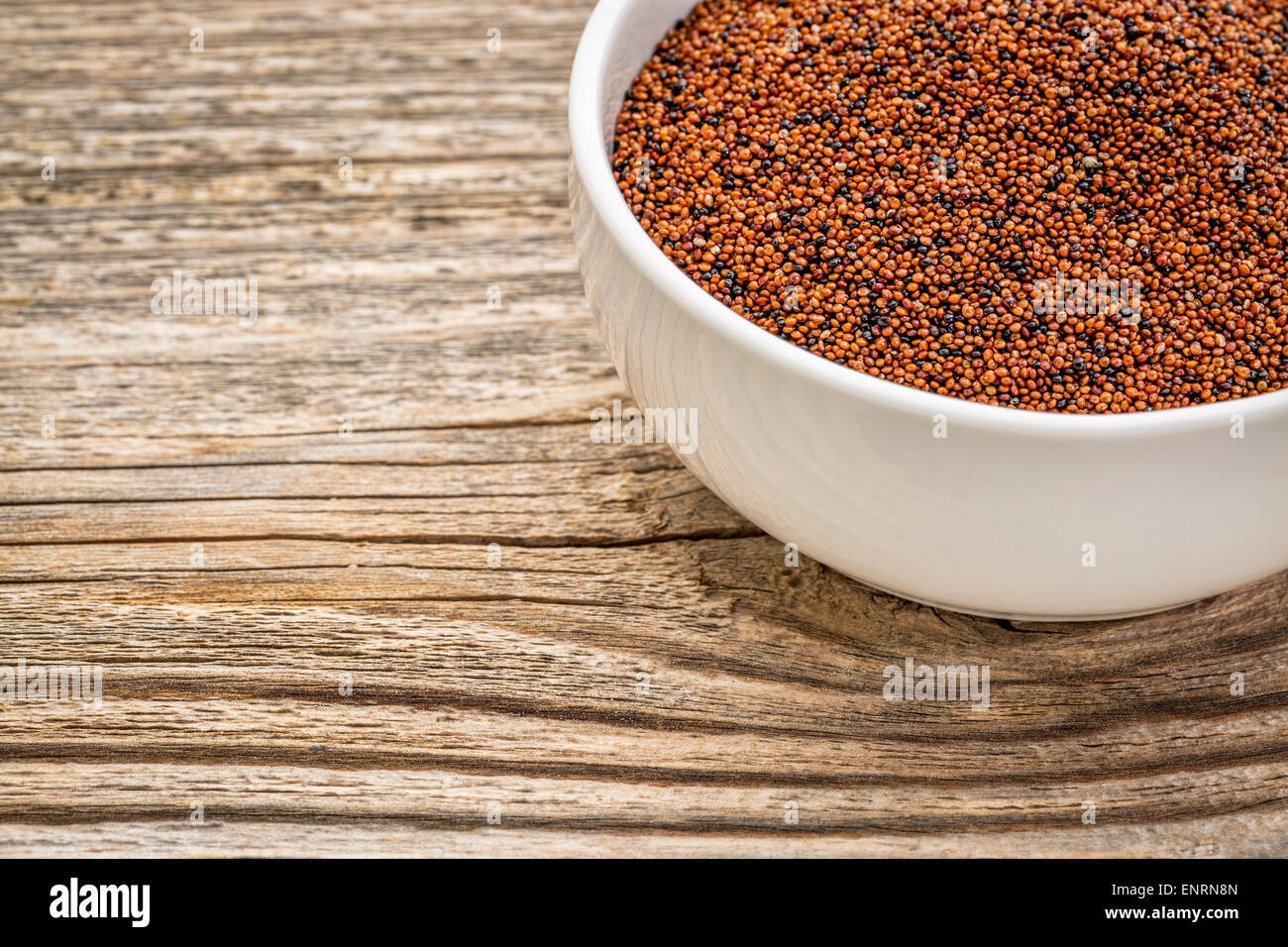 gluten free kaniwa grain (also known as baby quinoa) in a small ceramic bowl against grained wood Stock Photo