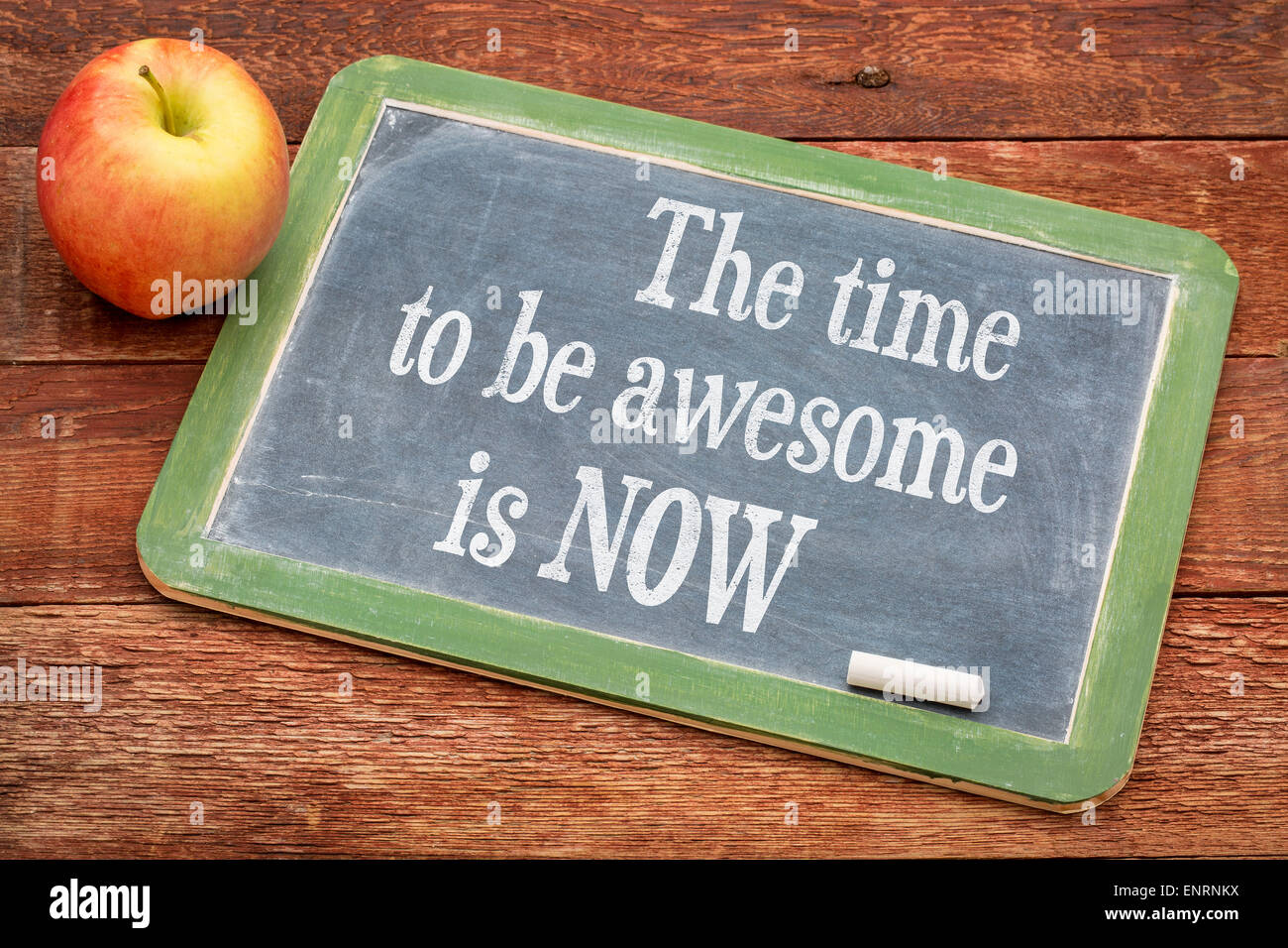 The time be awesome is now - motivational words on a slate blackboard against red barn wood Stock Photo