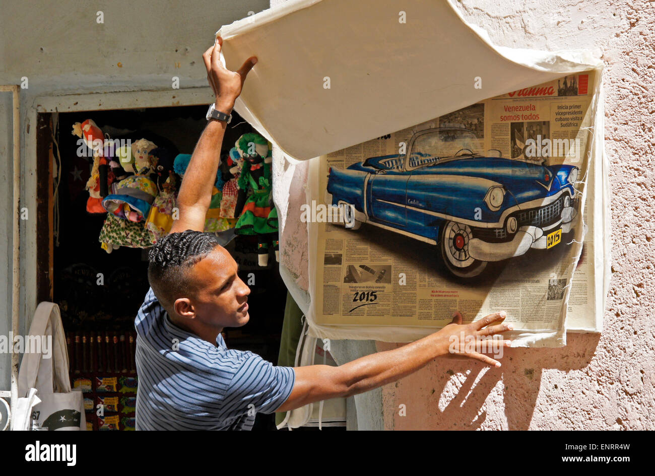 Artist showing his paintings outside shop in Habana Vieja (Old Havana), Cuba Stock Photo