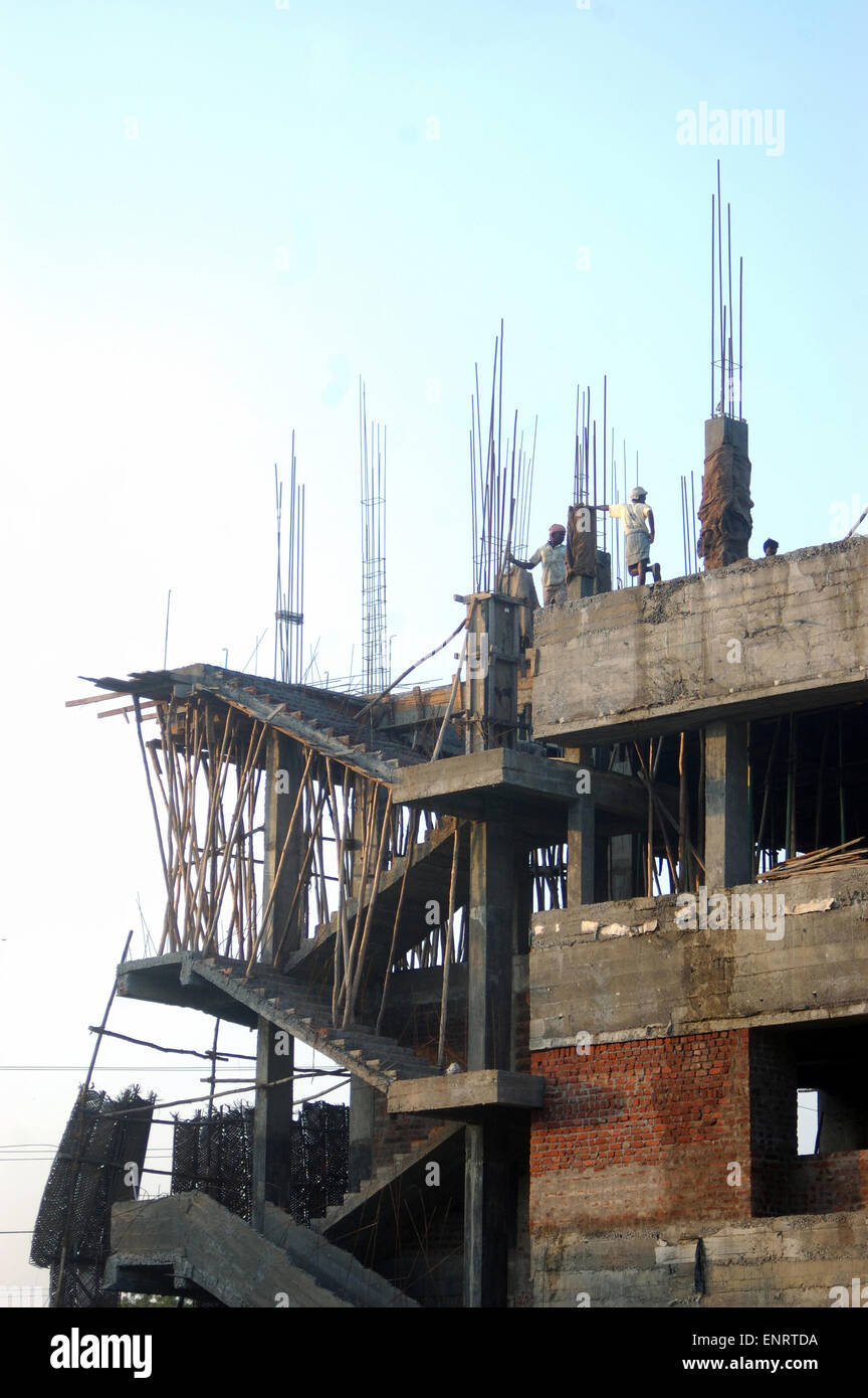 Men on skyline of construction site, Tamil Nadu, South India Stock Photo