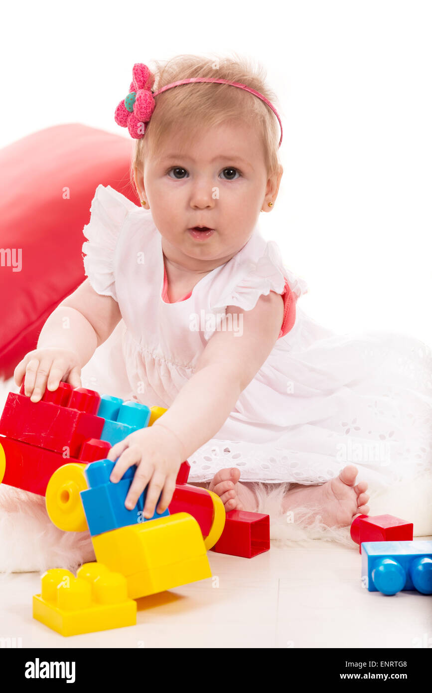 Amazed baby girl playing with colorful bricks toys Stock Photo