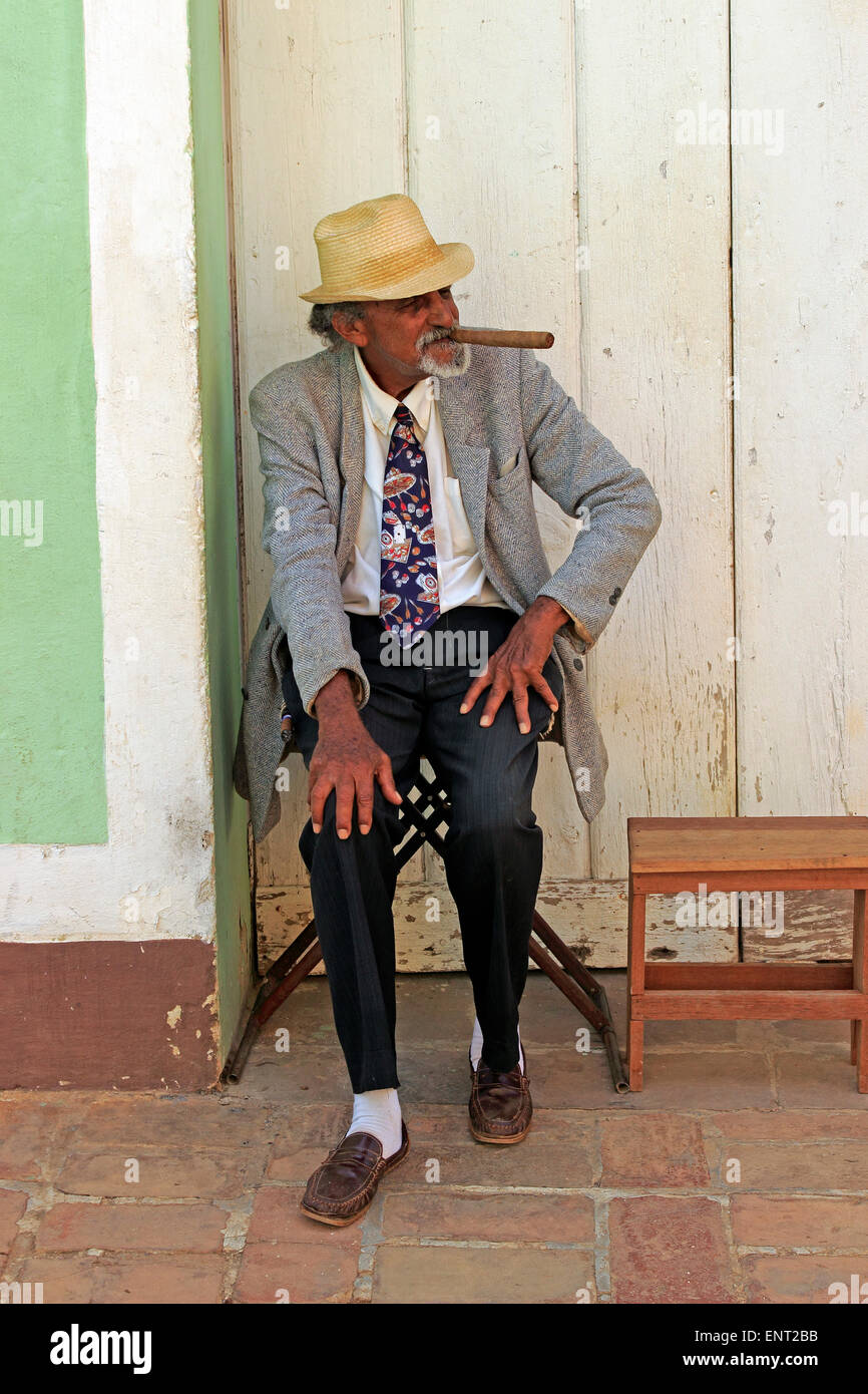 Elderly Cuban man with a large cigar entertaining the tourists, Trinidad, Cuba Stock Photo