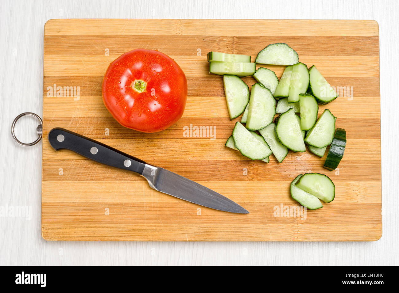 Board for cutting vegetables, a knife and cucumbers with tomatoes Stock ...