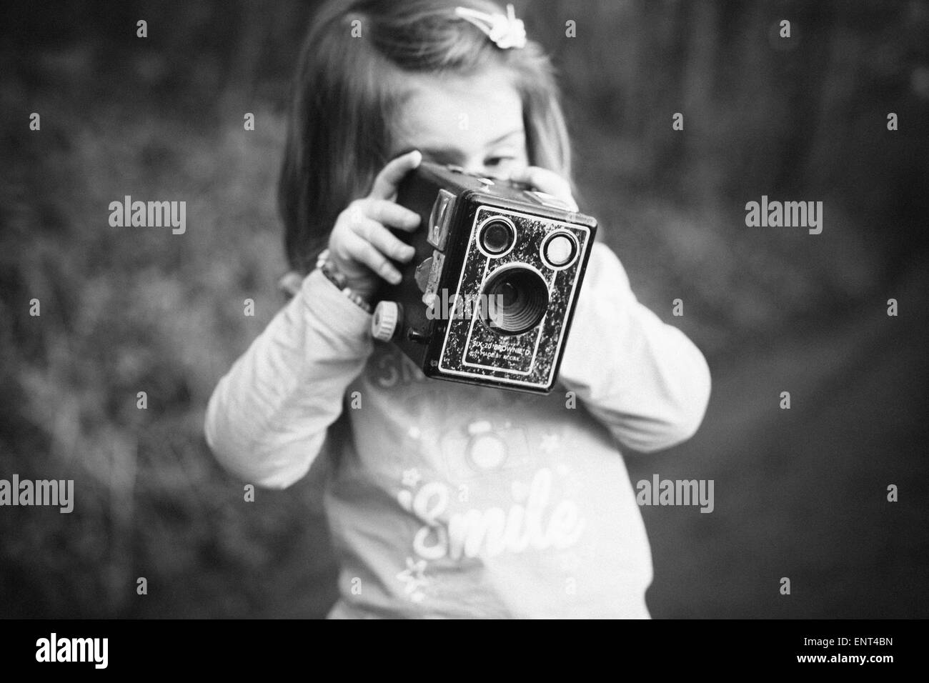 little girl using an old camera Stock Photo