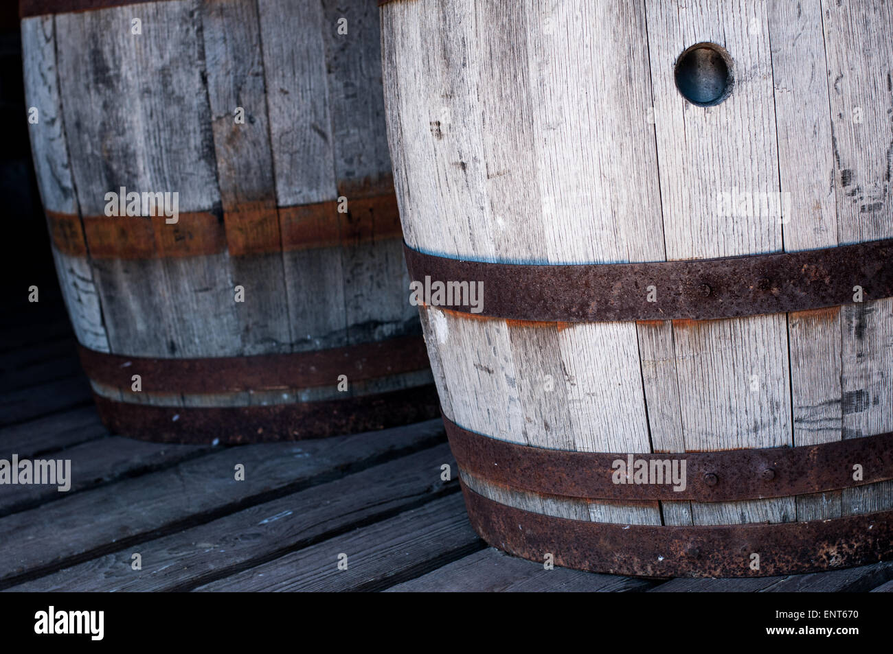 Two old, wooden barrels on a barn floor Stock Photo