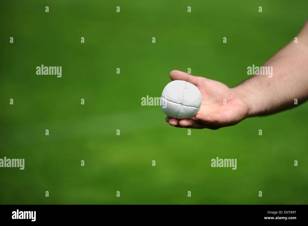 Hand holding a rounders ball. Rounders is a bat and ball game between