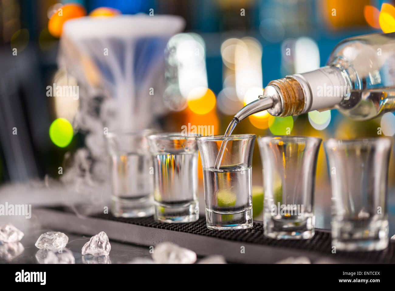 Barman pouring hard spirit into glasses in detail Stock Photo