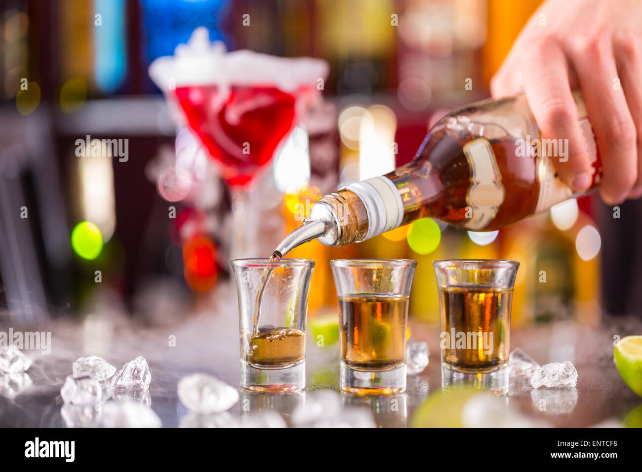 Barman pouring hard spirit into glasses in detail Stock Photo